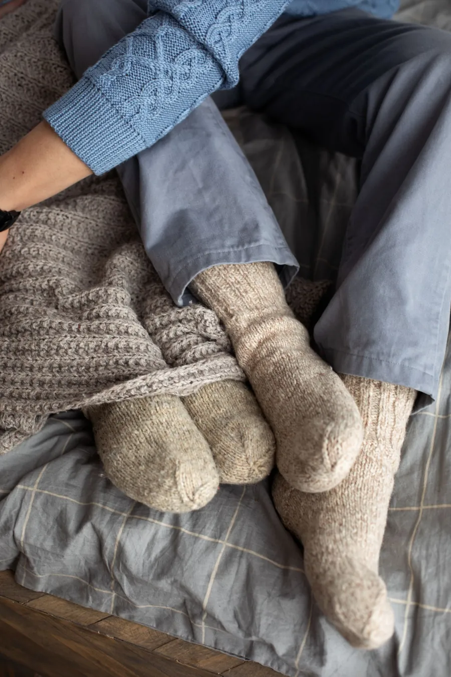 Good sleep in winter: warm wool socks on a cozy bed